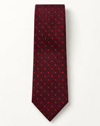 Cravate Richelieu à plat : fond rouge grenat et noir à micro-motifs géométriques et pois rouge vif.
