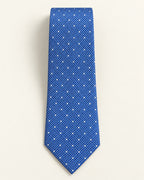 Cravate Scribe en jacquard de soie bleu à pois blancs, présentée à plat avec sa pointe classique.