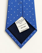 Dos de la cravate Scribe bleue à pois blancs, doublure marine et étiquette Hind Kroussa Paris, 100 % soie.