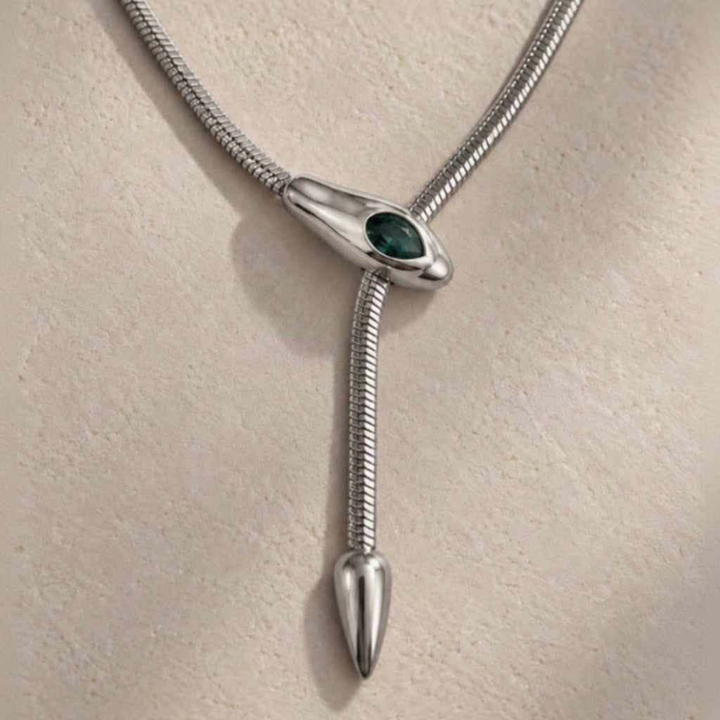 Détail d’un collier serpent argenté avec pierre verte