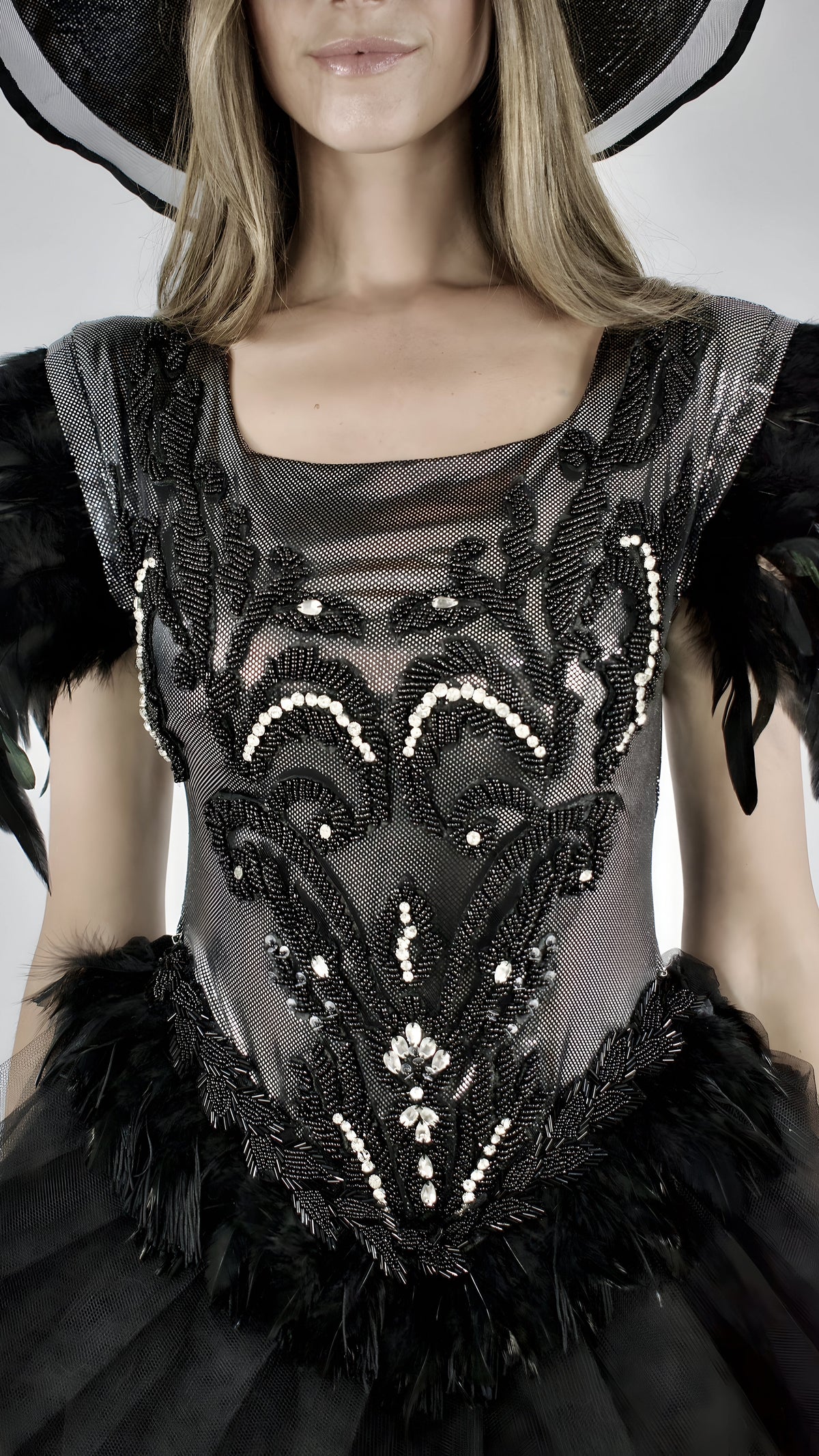 Détail d’un corsage noir brodé avec plumes