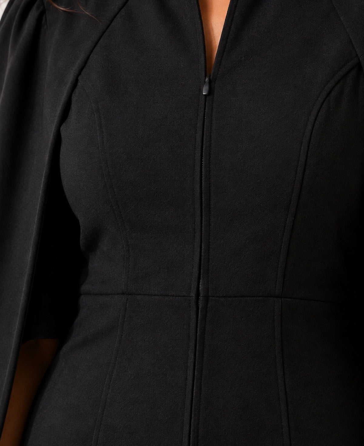 Detalle del cierre de un vestido negro con capa