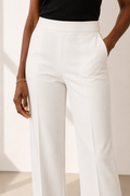 Detalle de la cintura alta de un pantalón blanco amplio