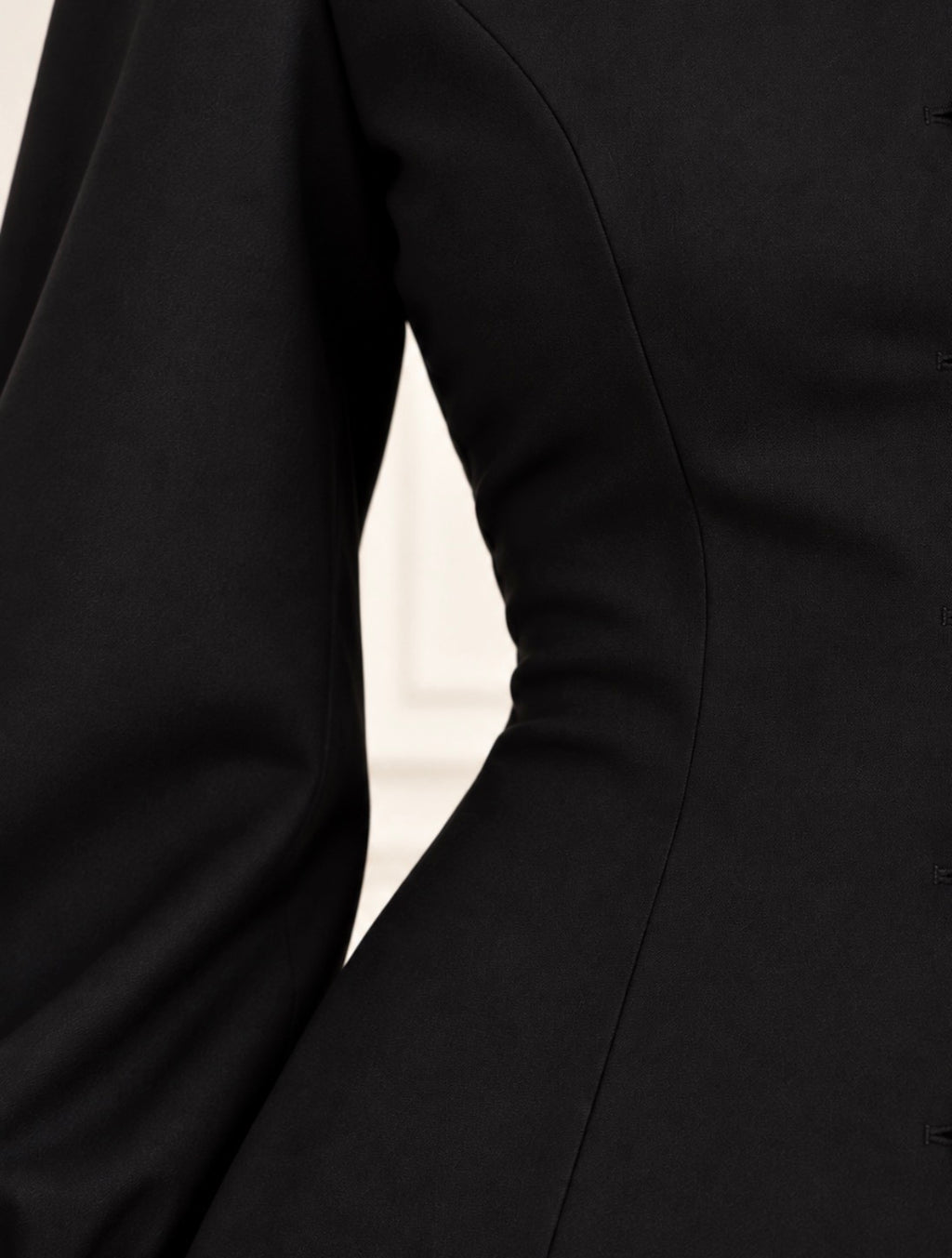 Detalle de las costuras entalladas de una blusa negra