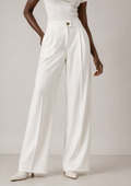 Détail des plis et jambes d’un pantalon blanc ample