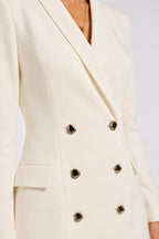 Detalle de las solapas y los botones de un vestido blazer crema