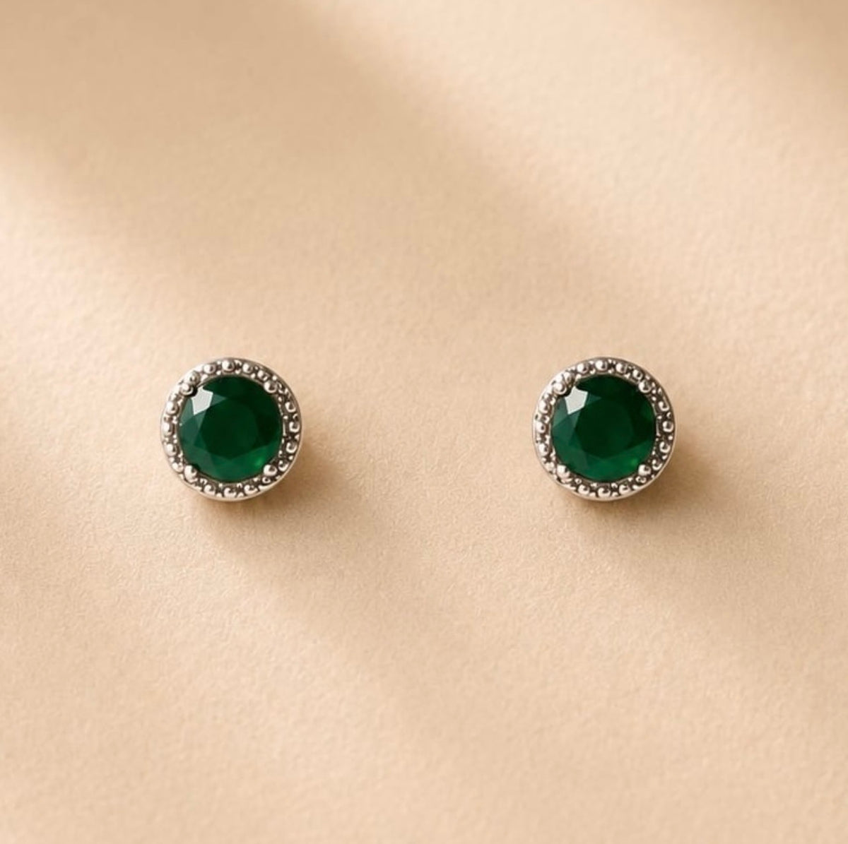 Deux boucles rondes vertes entourées de pierres claires