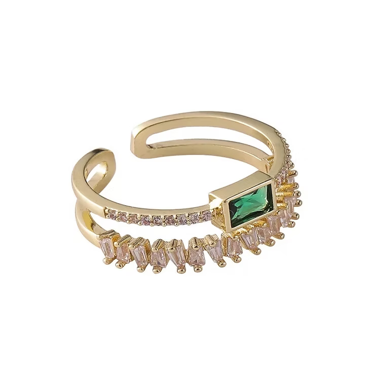 Bague ouverte dorée avec pierre verte et ornements clairs