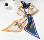 Foulard Rue de l’Abreuvoir — Un foulard aux motifs équestres dans une palette d’ivoire, de jaune doré et de bleu