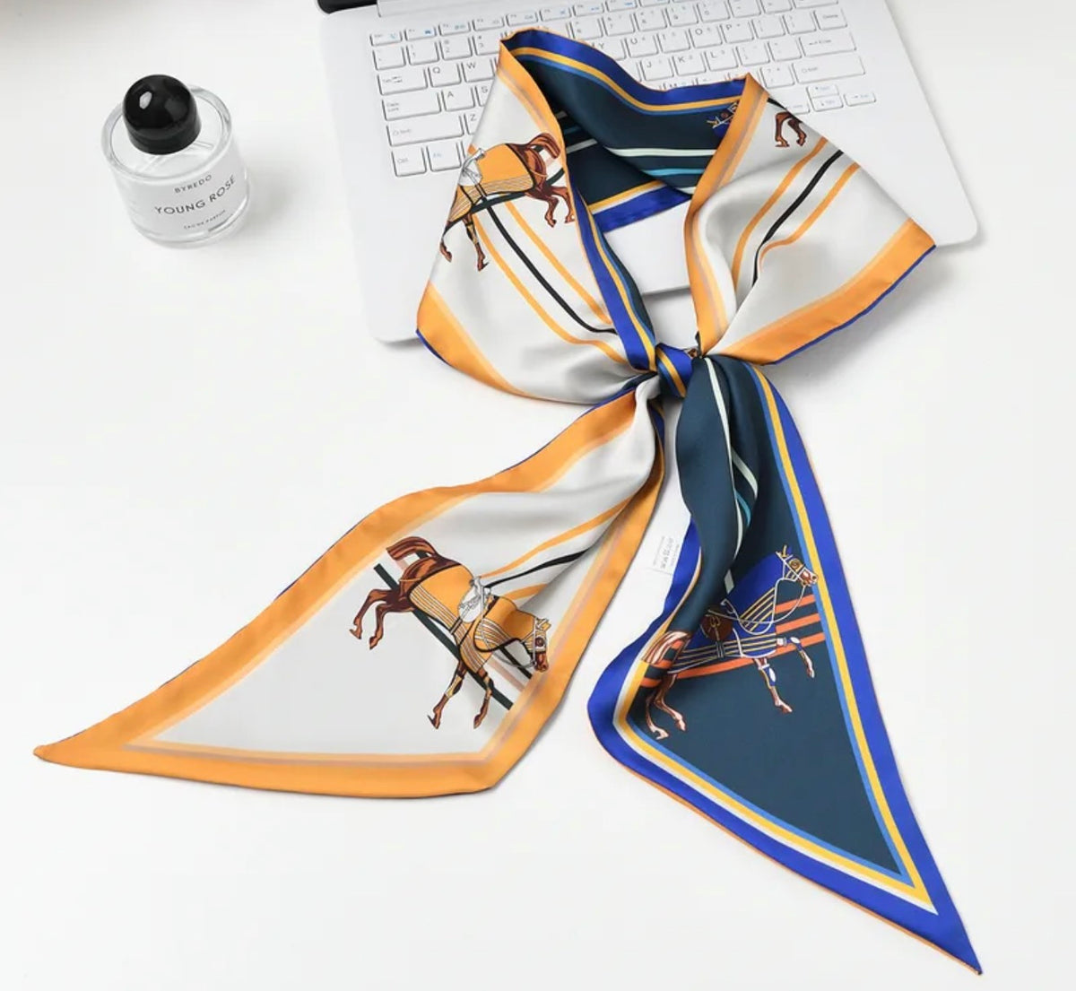 Foulard Rue de l’Abreuvoir — Un foulard aux motifs équestres dans une palette d’ivoire, de jaune doré et de bleu