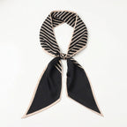 Foulard Rue Montorgueil — Un foulard aux rayures noires et beiges, avec des extrémités noires encadrées d’une bordure claire