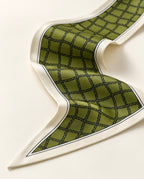 Détail du foulard Rue de Grenelle en soie : quadrillage noir sur fond vert olive, bordure ivoire soulignée d'un liseré noir.