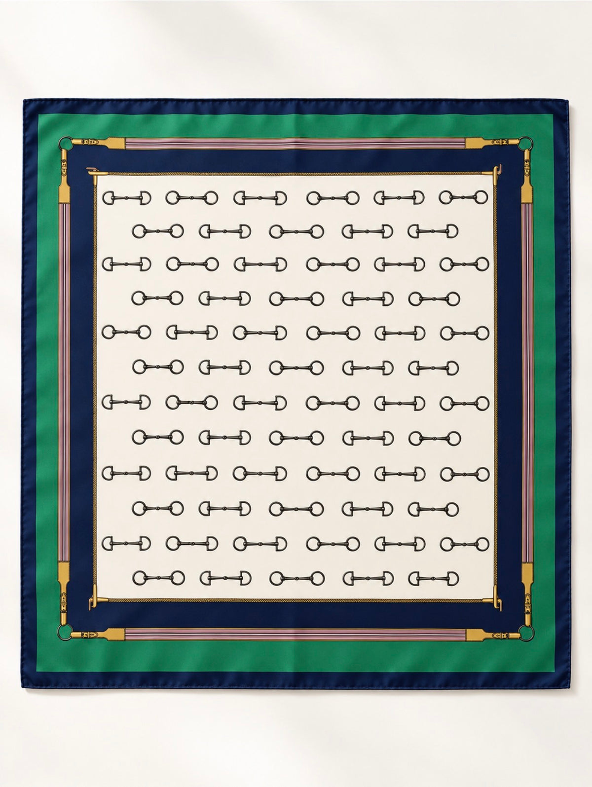 Foulard carré Rue de l’Éperon à plat, motif de mors noirs sur ivoire, encadré de bandes vert émeraude et bleu marine avec ornements dorés et roses.
