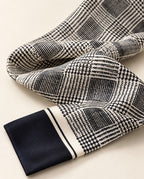 Zoom sur le foulard Rue de Verneuil en soie, motif de carreaux noir et ivoire, lignes entrecroisées et extrémité unie noire.
