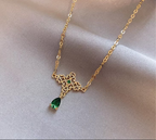 Pendente dorato con pietra verde appoggiato su raso