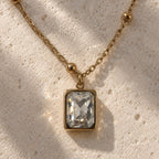 Pendentif rectangulaire transparent sur chaîne dorée à petites perles