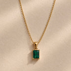 Colgante rectangular verde montado en una cadena dorada
