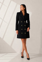 Robe blazer noire boutonnée portée avec escarpins noirs