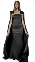 Abito lungo nero bustier con cappa su fondo chiaro